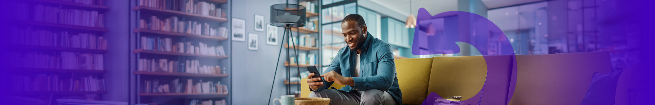 person on their mobile sat on a sofa in a library